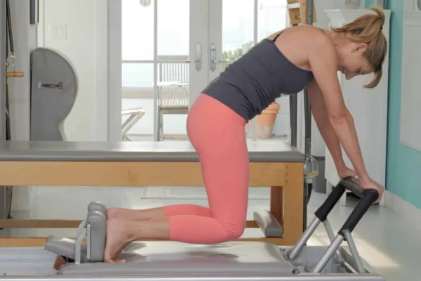 Bài tập Pilates Knee Stretches Round Back trên Reformer