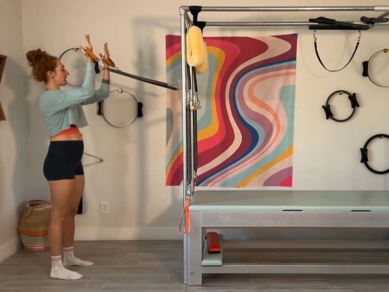 Tư thế chuẩn bị thực hiện Squats with Standing Arm Springs trên Cadillac