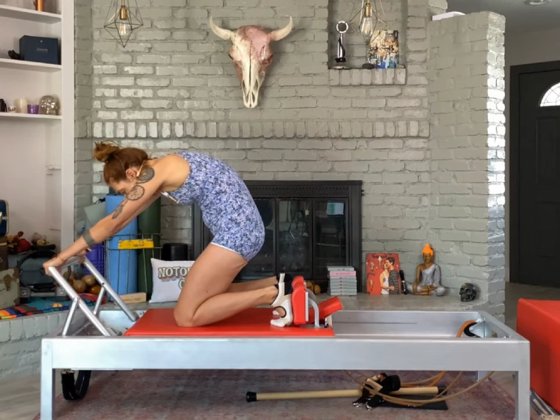 Các bước thực hiện bài tập Knee Stretches Round Back trên Reformer.