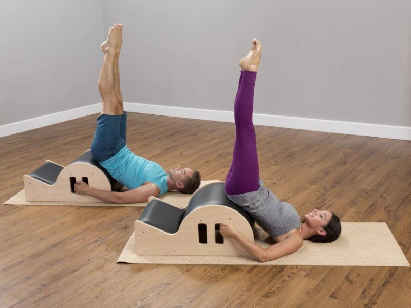 Perform Pilates Roll Over on the Spine Corrector.
