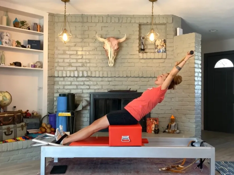 Steps to perform the Pilates Flat Back exercise on a Reformer.