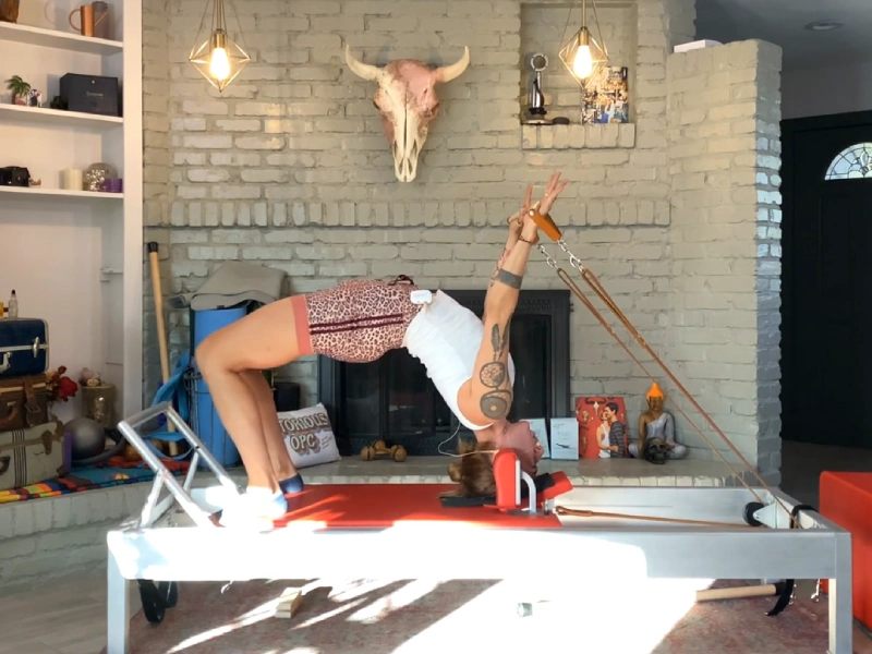 Instructions for performing Pilates Headstand with Straps on a Reformer.