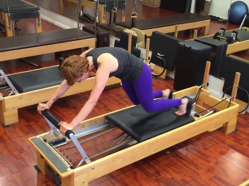 Steps to perform the Pilates Knee Stretches Knees Off exercise on the Reformer machine.