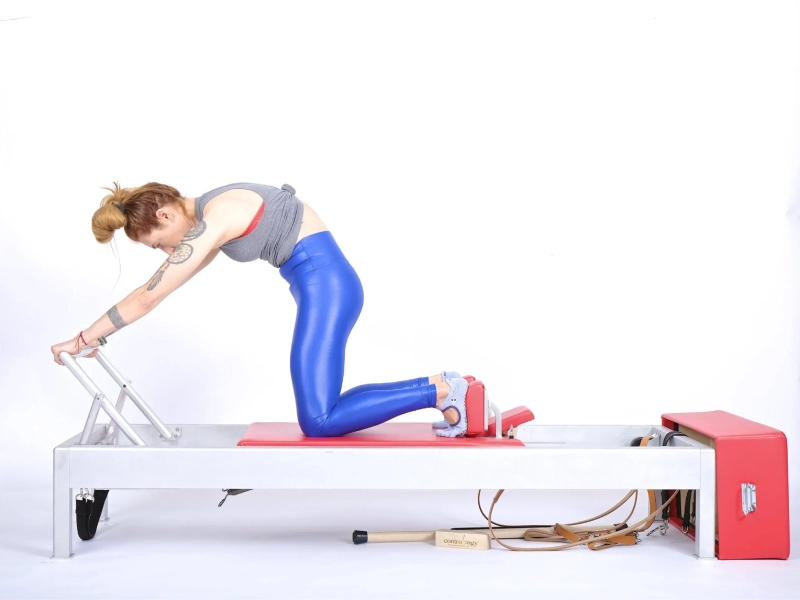 Benefits of Pilates Knee Stretches Round Back exercise on a Reformer.