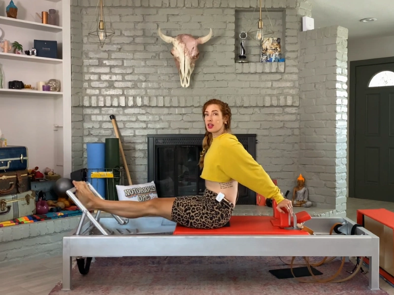 Steps to perform the Stomach Massage Hands Back exercise on the Reformer machine.