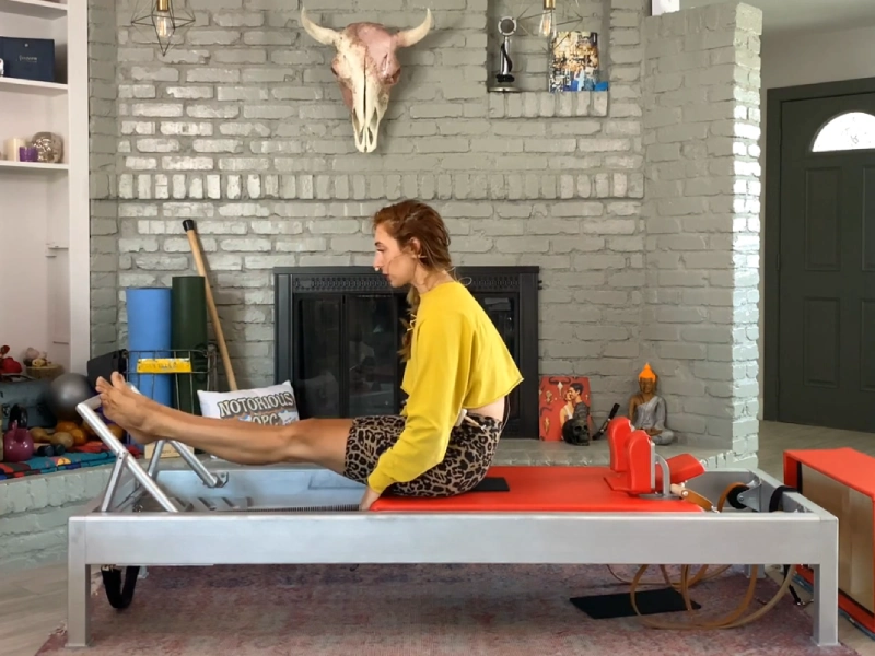 Steps to perform the Pilates Stomach Massage Round Back exercise on a Reformer.