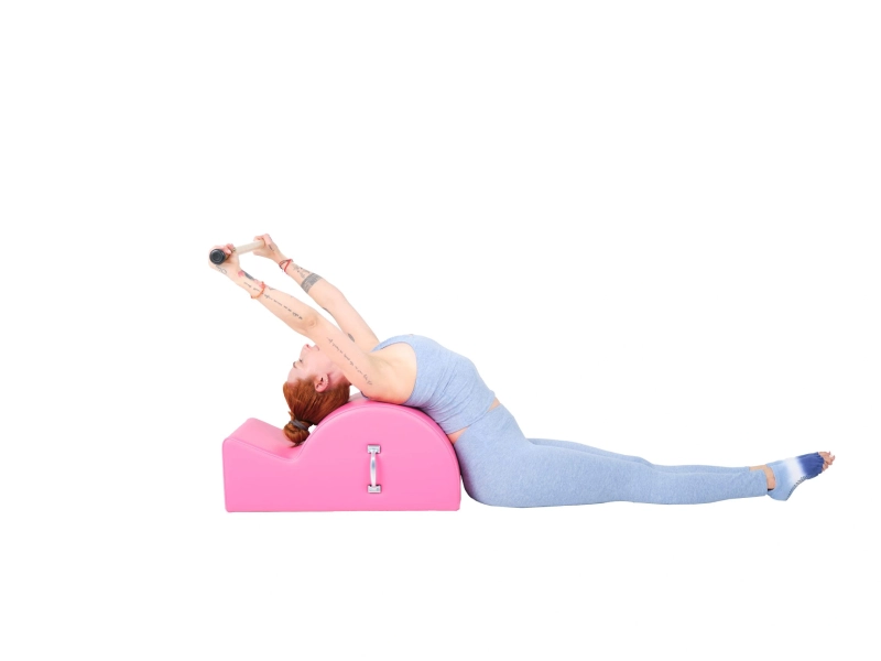 Pilates Reach Back with Bar exercise on Spine Corrector.