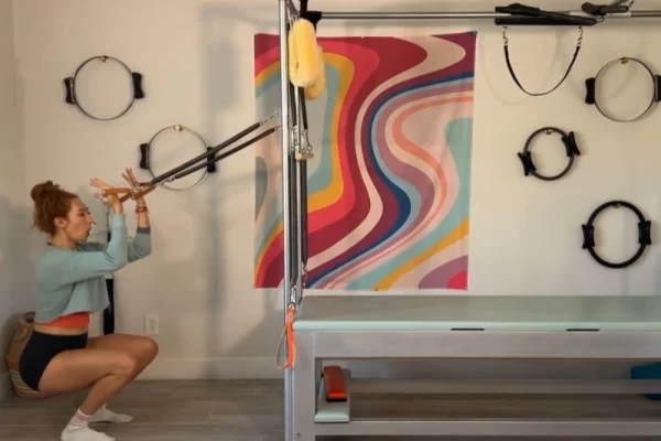 Perform Pilates Squats with Standing Arm Springs on Cadillac